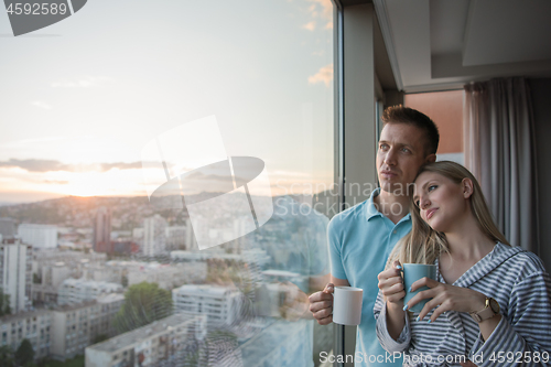 Image of young couple enjoying evening coffee by the window