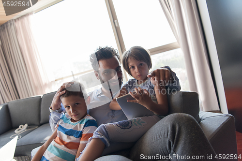 Image of happy young father spending time with kids