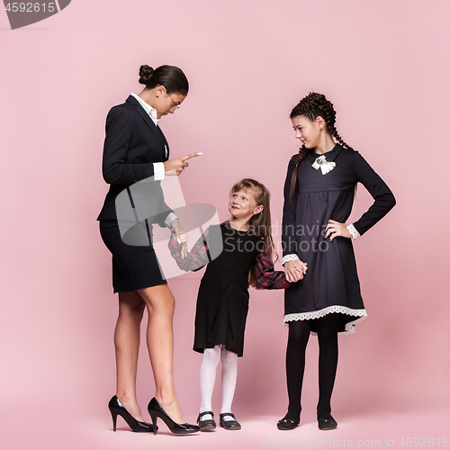 Image of Cute stylish children on pink studio background. The beautiful teen girls standing together