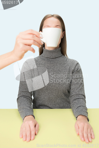 Image of The coffee break concept. woman before drinking coffee sitting indoor at table at studio