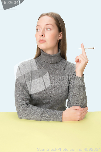 Image of Handsome young women smoking while sitting at table at studio. Trendy colors