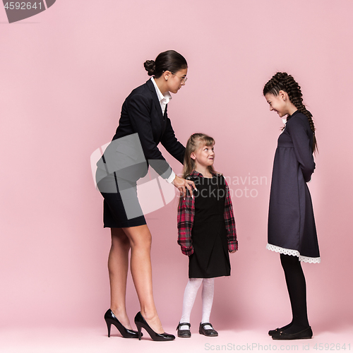 Image of Cute stylish children on pink studio background. The beautiful teen girls standing together