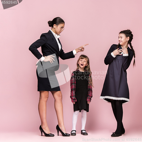 Image of Cute stylish children on pink studio background. The beautiful teen girls standing together