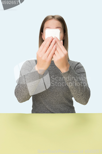 Image of The happy business woman sitting with mobile phone against pink background.