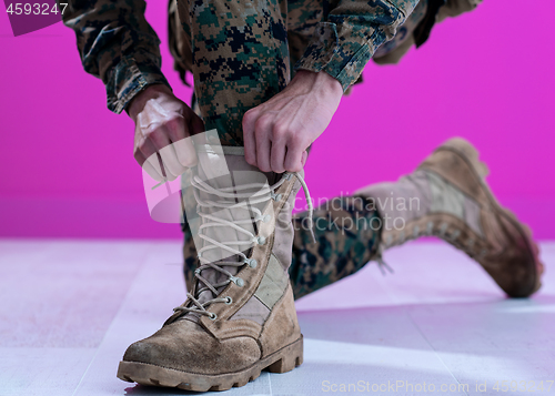 Image of soldier tying the laces on his boots