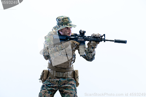 Image of soldier in action aiming laseer sight optics