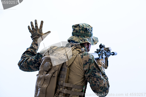 Image of soldier in action giving comands to team by hand sign