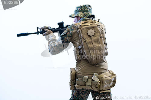 Image of soldier in action aiming laseer sight optics