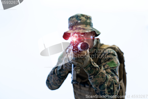 Image of soldier in action aiming laseer sight optics