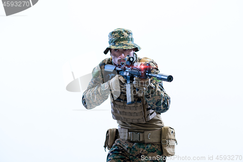 Image of soldier in action aiming laseer sight optics