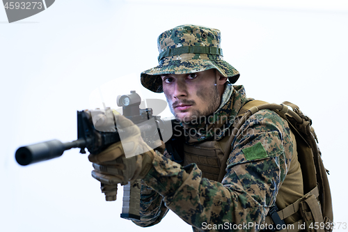 Image of soldier in action aiming laseer sight optics