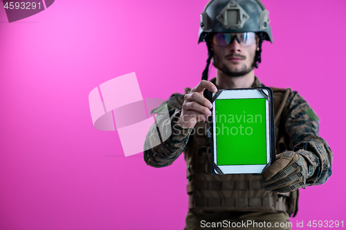 Image of soldier showing a tablet with a blank green screen