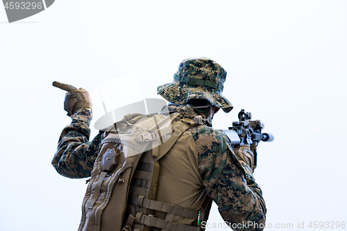 Image of soldier in action giving comands to team by hand sign