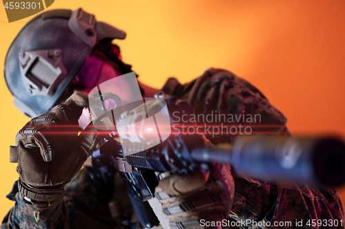 Image of soldier in action aiming laseer sight optics yellow background