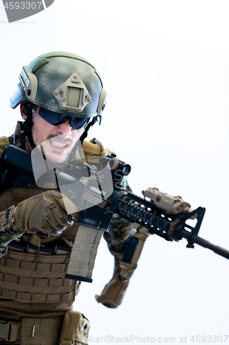 Image of soldier in action aiming laseer sight optics