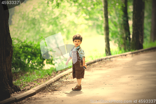 Image of little boy in an old park. Summer walk