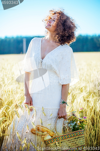 Image of beautiful middle-aged woman in a white dress in a field