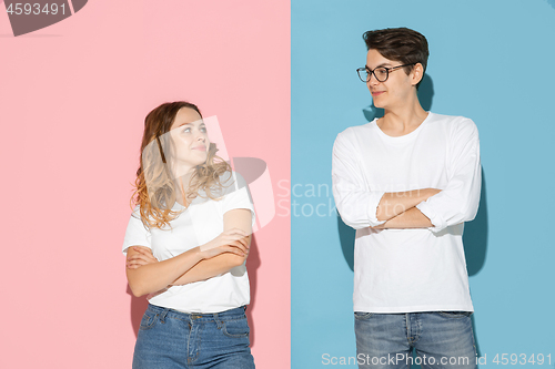 Image of Young emotional man and woman on pink and blue background