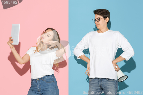 Image of Young emotional man and woman on pink and blue background