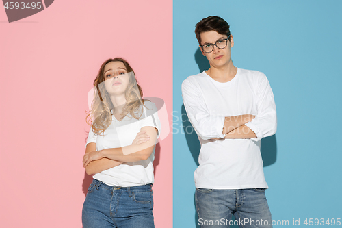 Image of Young emotional man and woman on pink and blue background