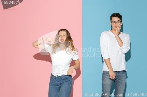 Image of Young emotional man and woman on pink and blue background