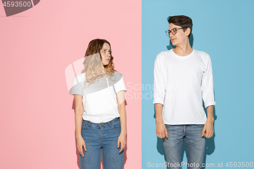 Image of Young emotional man and woman on pink and blue background