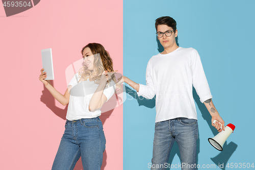 Image of Young emotional man and woman on pink and blue background