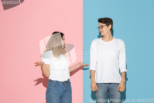 Image of Young emotional man and woman on pink and blue background