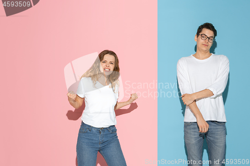 Image of Young emotional man and woman on pink and blue background