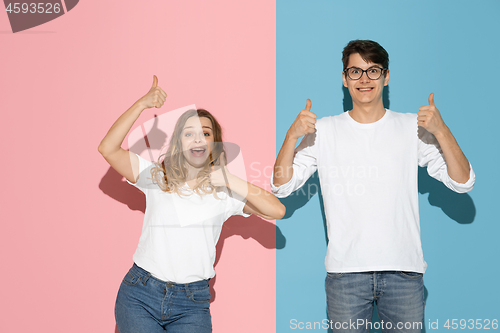 Image of Young emotional man and woman on pink and blue background
