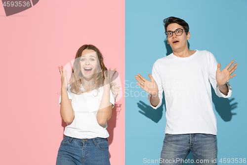 Image of Young emotional man and woman on pink and blue background