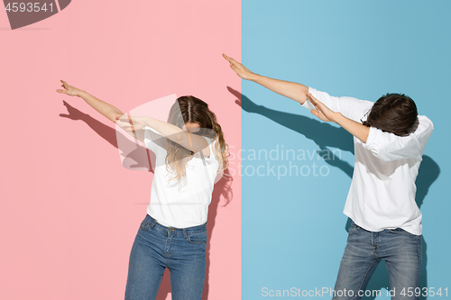 Image of Young emotional man and woman on pink and blue background