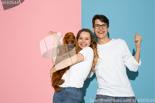 Image of Young emotional man and woman on pink and blue background