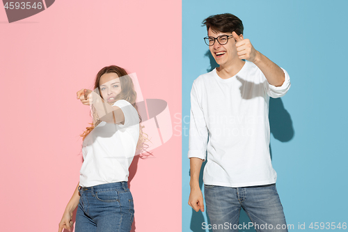 Image of Young emotional man and woman on pink and blue background