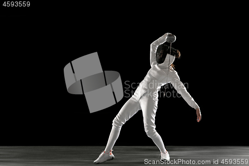 Image of Teen girl in fencing costume with sword in hand isolated on black background