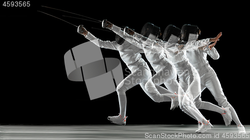 Image of Teen girl in fencing costume with sword in hand isolated on black background