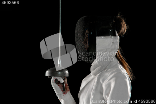 Image of Teen girl in fencing costume with sword in hand isolated on black background