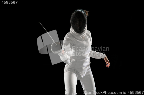 Image of Teen girl in fencing costume with sword in hand isolated on black background