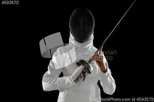 Image of Teen girl in fencing costume with sword in hand isolated on black background