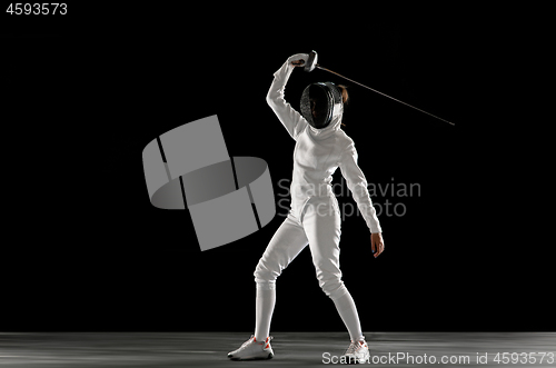 Image of Teen girl in fencing costume with sword in hand isolated on black background