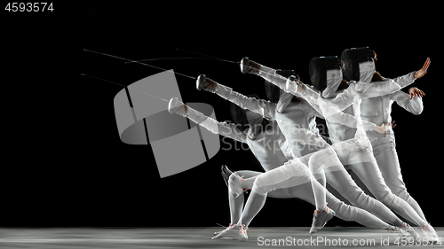 Image of Teen girl in fencing costume with sword in hand isolated on black background