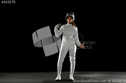 Image of Teen girl in fencing costume with sword in hand isolated on black background