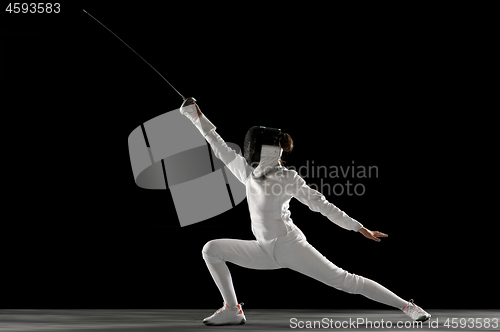 Image of Teen girl in fencing costume with sword in hand isolated on black background