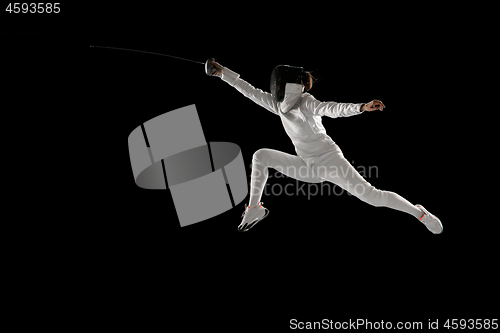 Image of Teen girl in fencing costume with sword in hand isolated on black background