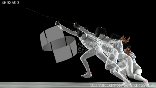 Image of Teen girl in fencing costume with sword in hand isolated on black background