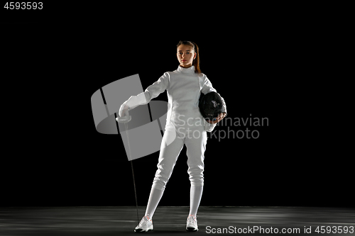 Image of Teen girl in fencing costume with sword in hand isolated on black background