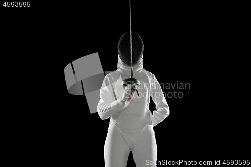 Image of Teen girl in fencing costume with sword in hand isolated on black background