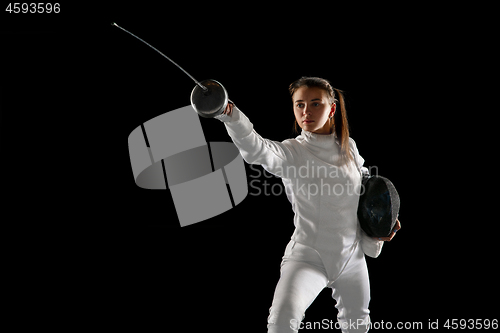 Image of Teen girl in fencing costume with sword in hand isolated on black background