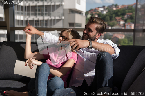 Image of Young couple watching television