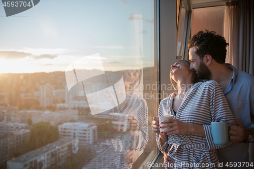 Image of young couple enjoying evening coffee by the window